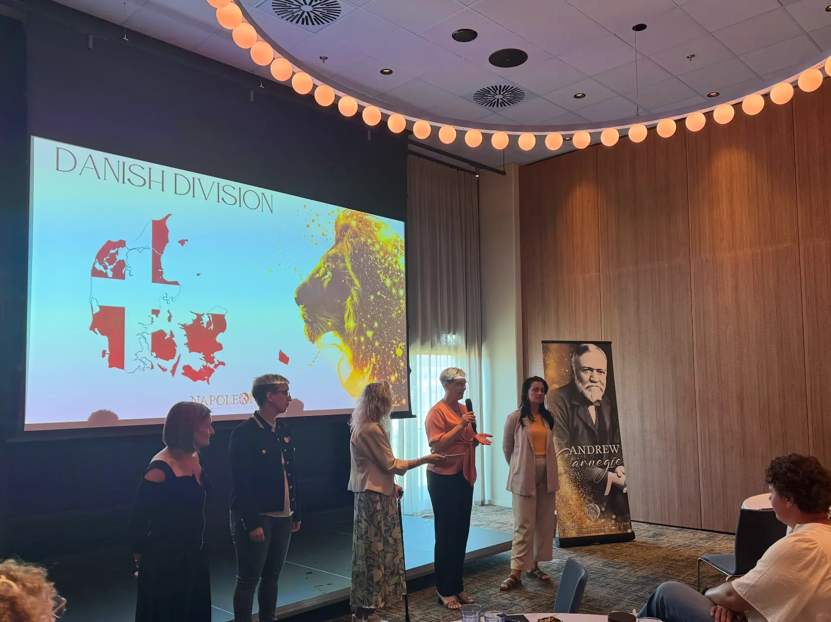 Napoleon Hill Institute Danish Division coaches on stage presenting the Denmark cohort
